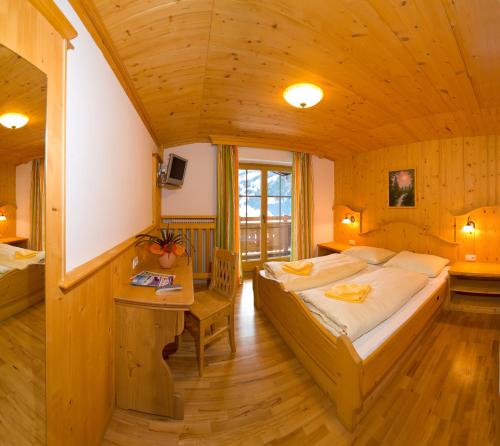 ein Schlafzimmer mit einem großen Bett und einer Holzdecke in der Unterkunft Panorama Pension in Großarl