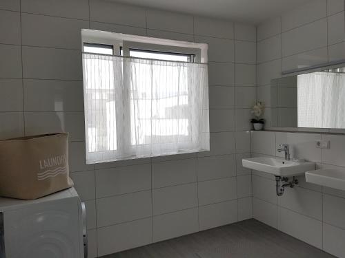 ライネにあるApartment by Janzenのバスルーム(トイレ、洗面台付)、窓が備わります。