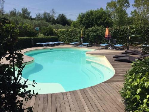 a large blue swimming pool with chairs and umbrellas at Agriturismo La Pecora Nera in Mulazzano