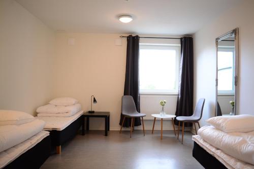 a room with two beds and a table and chairs at Alkoven Logi in Ullared