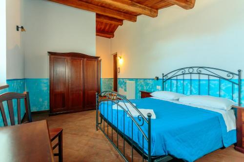 een slaapkamer met een blauw bed en een tafel bij Agriturismo Eutopia in San Leo