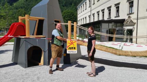 a man and a woman standing next to a playground at JUFA Hotel Spital am Pyhrn in Spital am Pyhrn