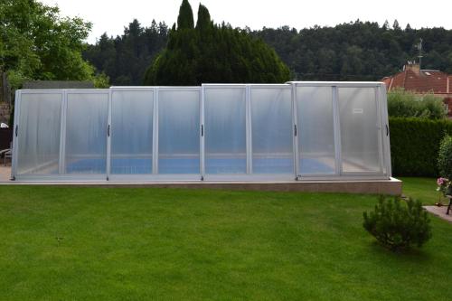 a greenhouse in a yard with a green lawn at Pension Betty in Tábor