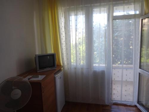 a room with a television and a window with a curtain at Hris in Chernomorets