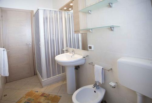 a white bathroom with a sink and a toilet at Terra del Sole in Favignana