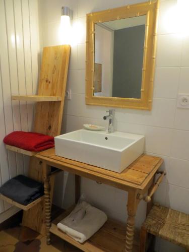 une salle de bain avec un lavabo blanc et un miroir dans l'établissement Le Grès 313, à Arpaillargues-et-Aureillac
