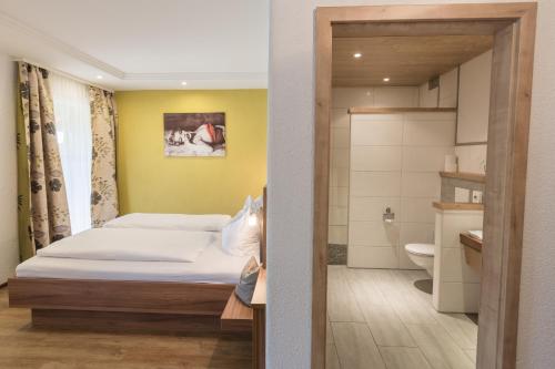ein kleines Schlafzimmer mit einem Bett und einem Badezimmer in der Unterkunft Sachsenbucherhof in Gurten