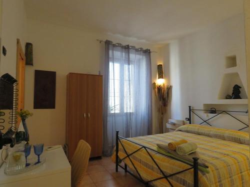 1 dormitorio con cama, mesa y ventana en Orgosolo B&B Sardegna, en Orgosolo