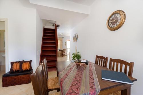 a dining room with a table and a clock on the wall at Aspalathos Suites in Akrotiri