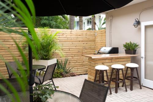 a patio with a bar with chairs and an umbrella at The Grand Resort and Spa & Worthington All Male in Fort Lauderdale