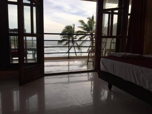 a room with a view of the ocean from a bedroom at The Ocean Park Beach Resort in Kovalam