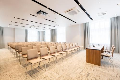 an empty lecture room with chairs and a podium at Grand Ascot Hotel in Kraków