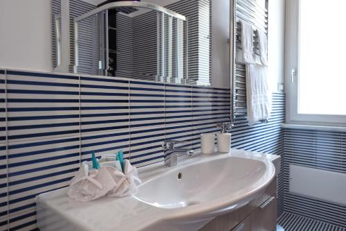La salle de bains est pourvue d'un lavabo blanc et d'un miroir. dans l'établissement CDA Apartament, à Minori