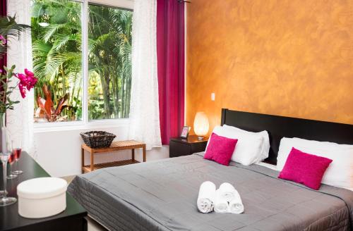 ein Schlafzimmer mit einem Bett mit zwei Flip-Flops darauf in der Unterkunft Instyle Residences at Infiniti Blu in Sosúa