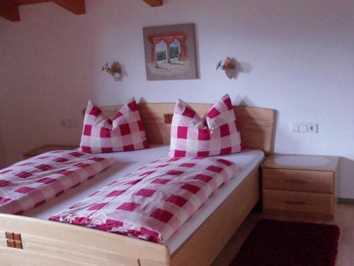 a bedroom with two beds with red and white pillows at Haus Franz in Hippach