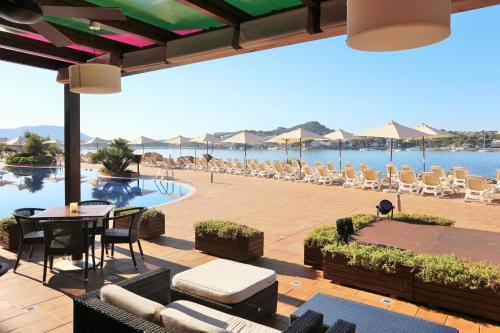 a patio with a table and chairs and a pool at Iberostar Selection Jardín del Sol Suites - Adults Only in Santa Ponsa