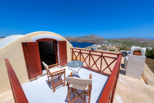 a balcony of a house with a table and chairs at Aspalathos Suites in Akrotiri