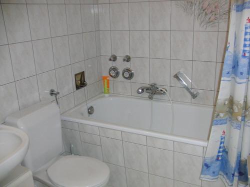 y baño con aseo, bañera y lavamanos. en Appartementhaus im Grün, en Bad Bellingen