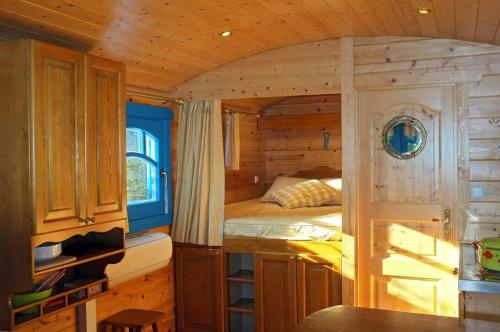 a small bedroom with a bed in a wooden cabin at Roulotte De Charme in Grasse