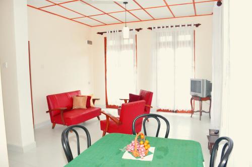 a living room with a table and chairs and a television at Ajanthas' Homestay in Kandy