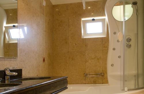 uma casa de banho com um chuveiro e um lavatório. em Hotel Quinta Bela S Tiago em Funchal