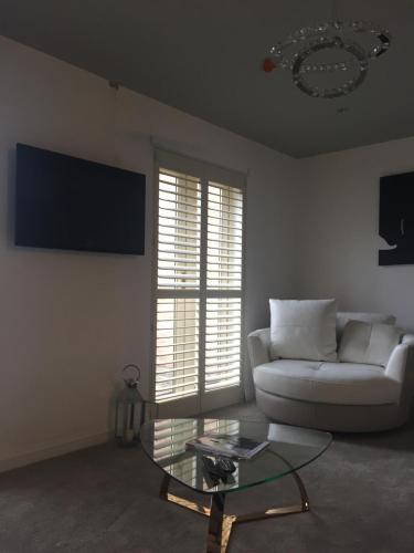 a living room with a white couch and a glass table at Main House in Rotherham