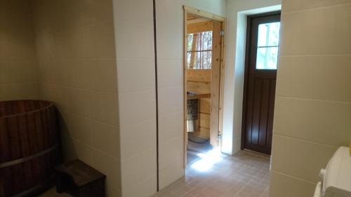 a bathroom with a walk in shower next to a door at Kultainen Kaava Cottages in Padasjoki