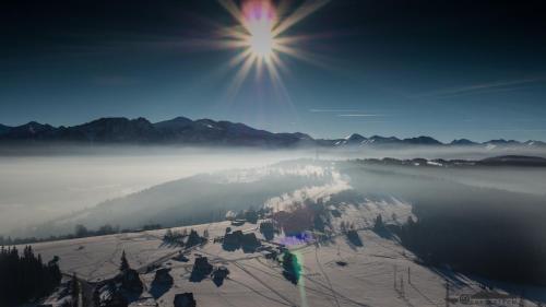 a view of a snowy mountain with the sun in the sky at Dom Wczasowy Na Szczycie in Zakopane