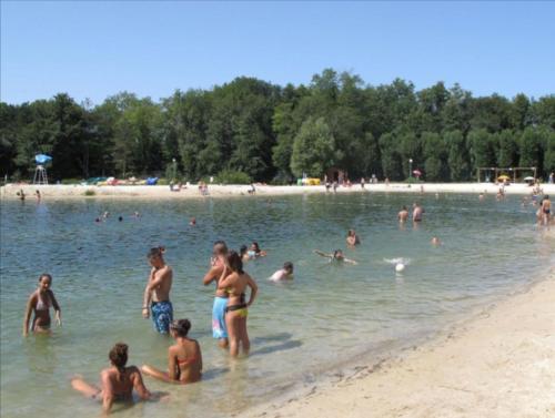 a group of people in the water at a beach at Auberge de La Vielle Halle in Souppes-sur-Loing