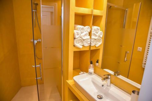 ein Bad mit einem Waschbecken, einer Dusche und einem Spiegel in der Unterkunft Boabdil Guesthouse in Ronda