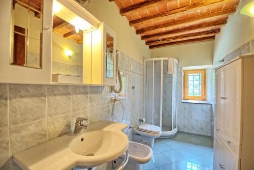 a bathroom with a sink and a toilet at Villa Poggio Conca by PosarelliVillas in Incisa in Valdarno