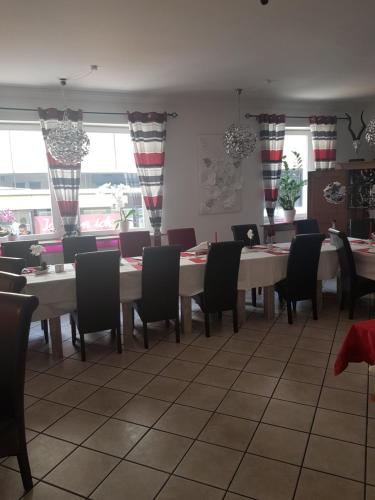 a dining room with a long table and chairs at Hotel Schweizer Stubb in Kaiserslautern