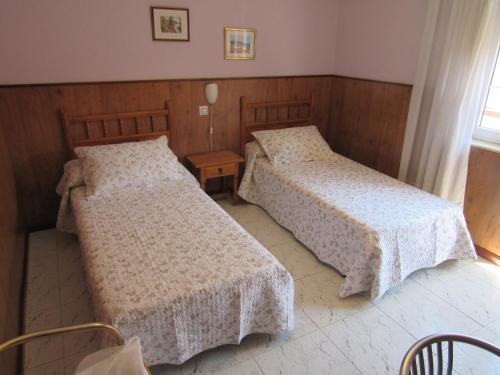 a bedroom with two beds and a table at Hostal Restaurante El Abuelo in Trobajo del Camino