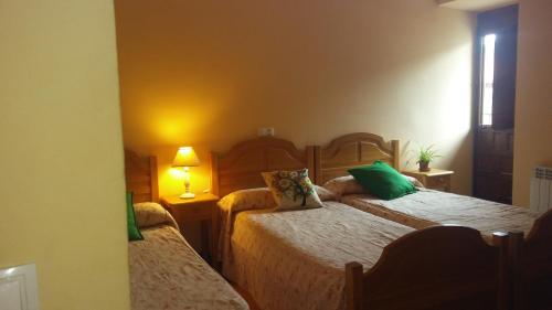 a bedroom with two beds with green pillows at Las Huellas de Cameros in Soto en Cameros