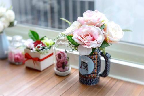 un jarrón lleno de rosas rosas sentadas en una mesa en chance encounter, en Luodong