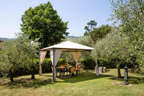 a gazebo with a table and chairs under it at Casa Vacanze Villa il Castellaccio in Lucolena in Chianti