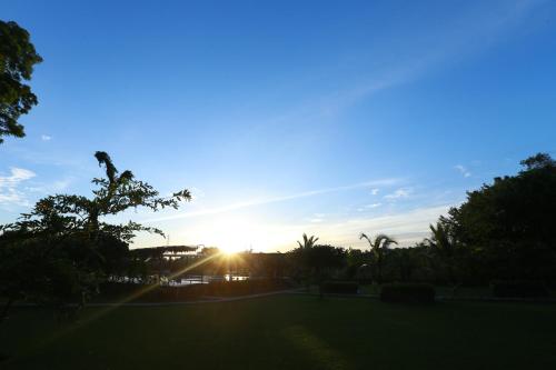 a sunset over a park with the sun setting at Eco Hotel Black & White - Anuradhapura in Mihintale