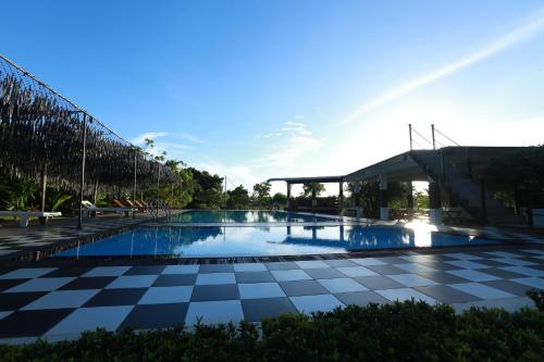 a swimming pool with a checkered floor and a building at Eco Hotel Black & White - Anuradhapura in Mihintale