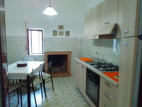 una cucina con tavolo e piano cottura forno superiore di Casa Skanderbek a Civita