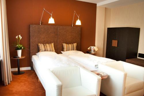a living room with a large white couch at Landhotel Heuvelzicht in Schin op Geul