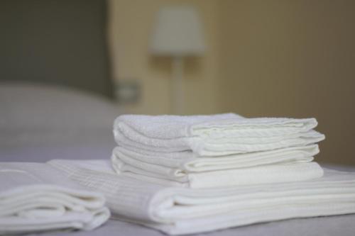 a pile of white towels stacked on a bed at Dépendance La Casetta in Castellammare di Stabia