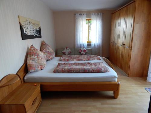 a bedroom with a bed and a wooden cabinet at Ferienwohnung Am Alten Berg in Ochsenfurt