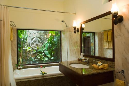 baño con bañera, lavabo y ventana en Cham Villas Resort, en Mui Ne