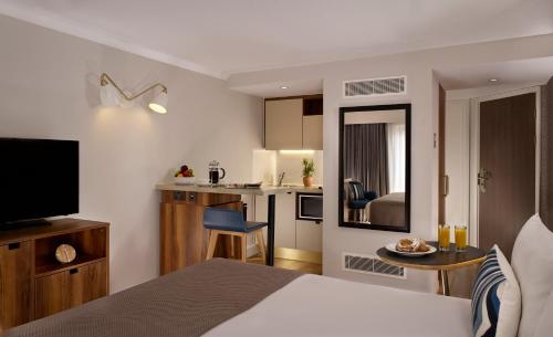 a hotel room with a bed and a kitchen at Citadines Barbican London in London