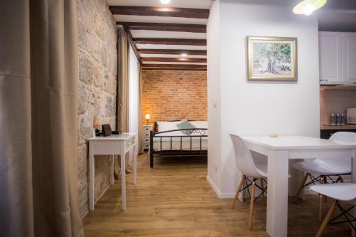 a room with a table and chairs and a bedroom at Studio apartman Ana in Split