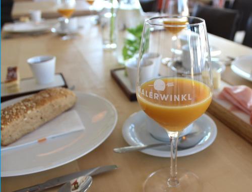 a glass of orange wine sitting on a table at Malerwinkl Restaurant + Kunsthotel in Hatzendorf