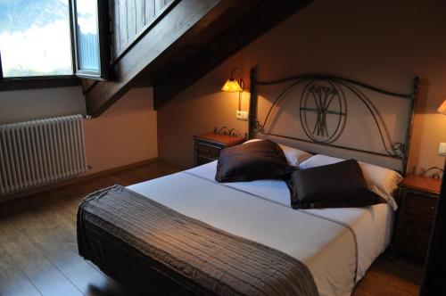 1 dormitorio con 1 cama grande y 2 ventanas en Hotel Areulo, en Cerler