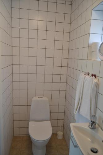 
a white toilet sitting next to a white sink at Bredebro Kro in Bredebro
