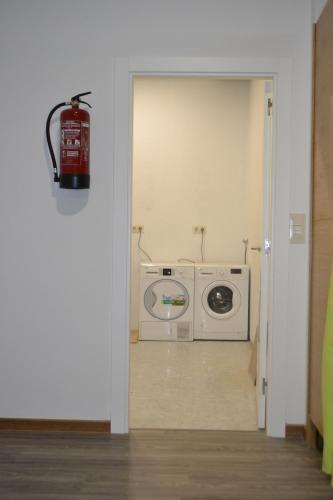 uma lavandaria com uma máquina de lavar roupa e um extintor de incêndio em Santiago de Vilavella em Redondela