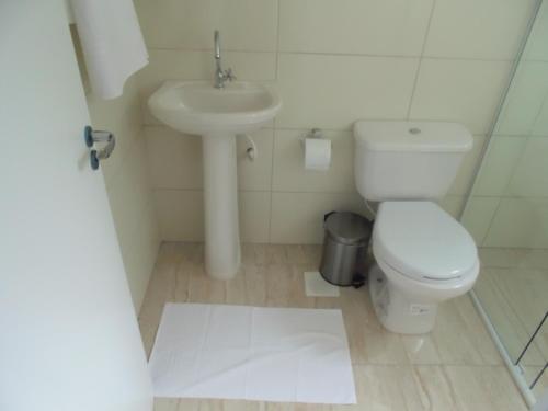 La salle de bains est pourvue de toilettes et d'un lavabo. dans l'établissement Hotel Anjos LTDA, à Gravataí